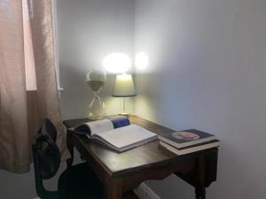 een bureau met een lamp en boeken erop bij Home Away From Home in Baltimore