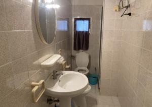 a bathroom with a sink and a toilet and a mirror at Appartamento Via Marinedda 9 Isola Rossa in Isola Rossa +14 photos