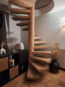 a wooden spiral staircase in a room with a vase at Villa Sisyphe chambre"la jeanette" in Le Thoronet