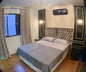 un dormitorio con una cama y una ventana en Frente mar, espaço e conforto, en Balneário Camboriú