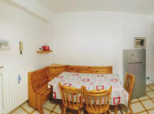 a kitchen with a table with chairs and a refrigerator at Il Roseto di Anna Home in Tagliacozzo