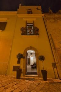 an entrance to a building with two potted plants at Zenthe Small Luxury B&B in Brindisi