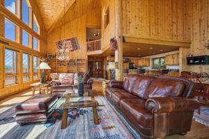 a living room with a leather couch and a table at Hamilton Creek Cabin home in Silverthorne