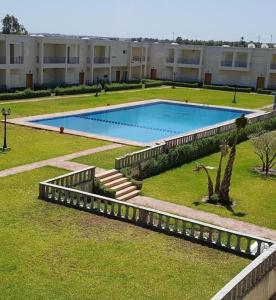 a large swimming pool in front of a building at Villa avec piscine, Hacienda Beach Sidi Rahal in Sidi Rahal