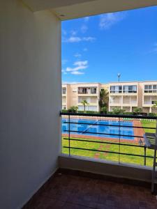 a room with a balcony with a view of a pool at Villa avec piscine, Hacienda Beach Sidi Rahal in Sidi Rahal