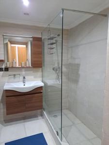 a bathroom with a glass shower and a sink at Villa avec piscine, Hacienda Beach Sidi Rahal in Sidi Rahal