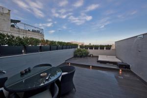 eine Terrasse mit einem Tisch und Stühlen auf dem Dach in der Unterkunft Zenthe Small Luxury B&B in Brindisi