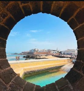 a view of the beach from a stone archway at MOjA HOUSE in Essaouira
