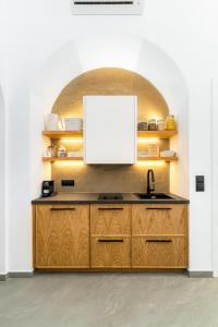a kitchen with a sink and a whiteboard on the wall at Skepi Town Houses in Mikonos