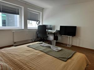 a bedroom with a bed and a desk and two windows at FC Dortmund Center - Premium Room in Dortmund