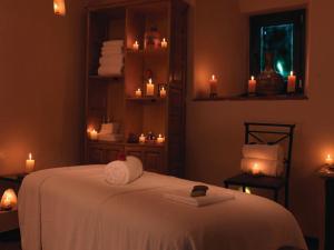 a room with a bed with candles and towels at Monasterio, A Belmond Hotel, Cusco in Cusco