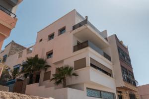 a building with palm trees in front of it at tayyurt host in Agadir
