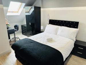 海斯Letzi Premium Cozy Retreat Private En-Suite Rooms, Heathrow Airport的卧室配有黑白床和书桌。