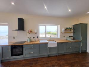 a kitchen with gray cabinets and a counter top at Maggies Cottage Inishmore in Inis Mor