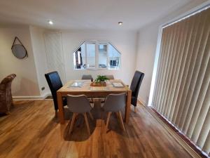 a dining room table with chairs and a mirror at City Centre Semi-Detached-House in Nottingham