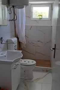 a bathroom with a toilet and a sink and a window at Apartments with parking space Pag - 6325 in Pag