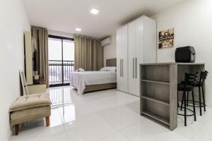 a hotel room with a bed and a desk and chair at LF111 - Studio Moderno no Tatuapé (metrô carrão) in Sao Paulo