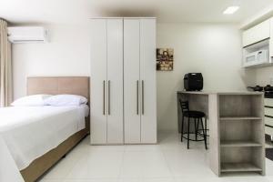 a bedroom with a large white bed and a desk at LF111 - Studio Moderno no Tatuapé (metrô carrão) in Sao Paulo