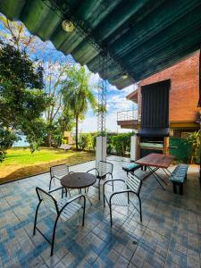 eine Terrasse mit einem Tisch, Stühlen und einem Kamin in der Unterkunft Casa frente al Río Paraná in Ituzaingó