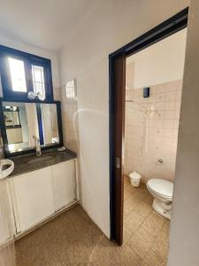 ein Badezimmer mit Toilette, Waschbecken und Spiegel in der Unterkunft Casa frente al Río Paraná in Ituzaingó + 5 Fotos