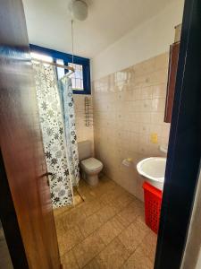 ein Badezimmer mit Dusche, Toilette und Waschbecken in der Unterkunft Casa frente al Río Paraná in Ituzaingó