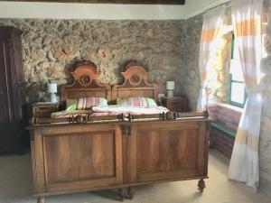 a bedroom with a wooden bed and a stone wall at Family friendly house with a swimming pool Bribir, Novi Vinodolski - 23474 in Bribir +17 photos