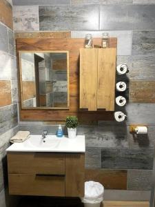 a bathroom with a sink and a mirror and towels at Vibe Beach House in Herolds Bay