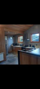 Una cocina grande con gabinetes de madera y encimera. en Altitud 270, en Villa La Angostura