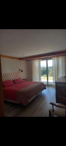 Un dormitorio con una cama grande y una ventana grande. en Altitud 270, en Villa La Angostura