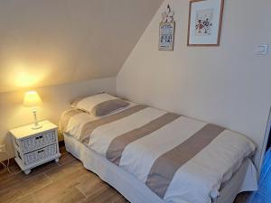 a bedroom with a bed and a night stand with a lamp at Cottage in Plouneour-Trez with Sea View in Plounéour-Trez