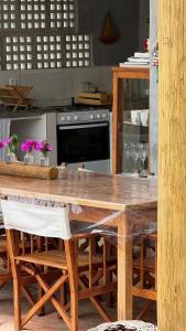 eine Küche mit einem großen Holztisch mit Stühlen in der Unterkunft Casa Mangaba da Praia in Corumbau