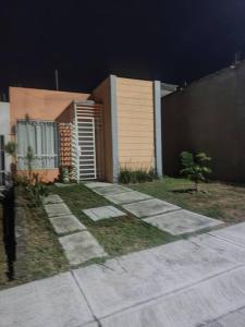 a house with a sidewalk next to a fence at Casa Orquídea in Morelia