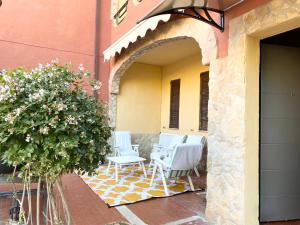 a patio with white chairs and a building at Villa Franca in Capoterra