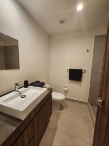 Un baño con un lavabo blanco y un inodoro. en New and luxury department, en Puerto Vallarta