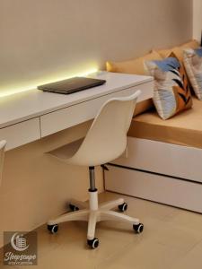 a desk with a laptop and a chair in a bedroom at SleepScape Staycation in Manila