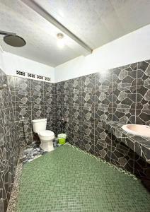 a bathroom with a toilet and a sink at De Pointé Resort & Resto in Campaka