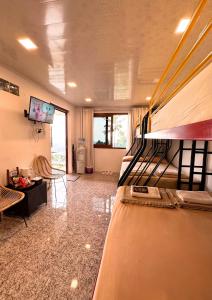 a bedroom with a bunk bed and a living room at De Pointé Resort & Resto in Campaka