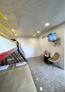 a room with a bunk bed and a flat screen tv at De Pointé Resort & Resto in Campaka