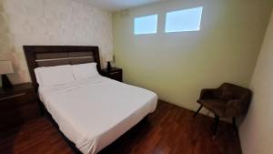 una camera da letto con un letto bianco e una sedia di 3 RECS: HERMOSO,AMPLIO E INMEDIATO A PASEO REFORMA a Città del Messico