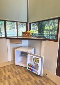 a small white refrigerator in a room with windows at De Pointé Resort & Resto in Campaka