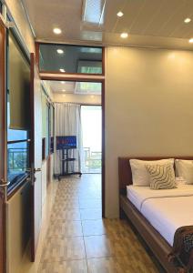 a bedroom with a bed and a large window at De Pointé Resort & Resto in Campaka