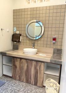 a bathroom counter with a sink and a mirror at De Pointé Resort & Resto in Campaka