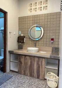 a bathroom with a sink and a mirror at De Pointé Resort & Resto in Campaka