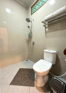 a bathroom with a toilet and a shower at De Pointé Resort & Resto in Campaka
