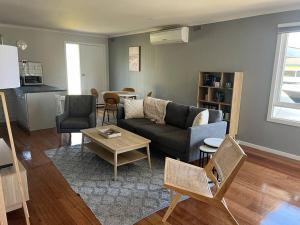a living room with a couch and a table at Cowes Cosy Cottage in Phillip Island