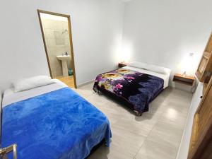 Un dormitorio con dos camas y un espejo. en Apartahotel La Gruta, en Jericó
