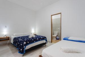 Un dormitorio con dos camas y un espejo. en Apartahotel La Gruta, en Jericó