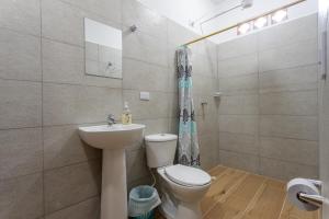 un baño con inodoro y lavabo en Apartahotel La Gruta, en Jericó
