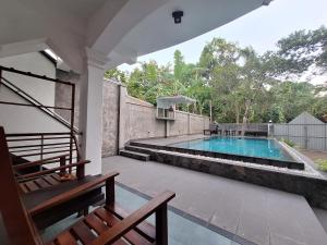 a house with a swimming pool with a bench at Villa Goodwill Paradise in Hikkaduwa