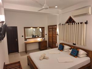 a bedroom with a bed and a sink and a mirror at Villa Goodwill Paradise in Hikkaduwa